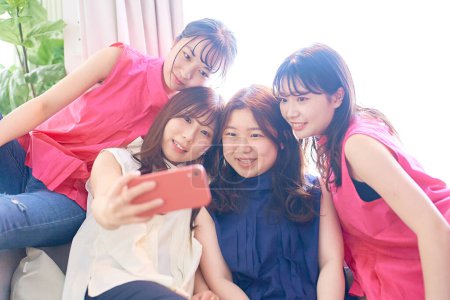 Téléchargez les photos : 4 femmes prenant un selfie à une fête de filles à l'intérieur - en image libre de droit