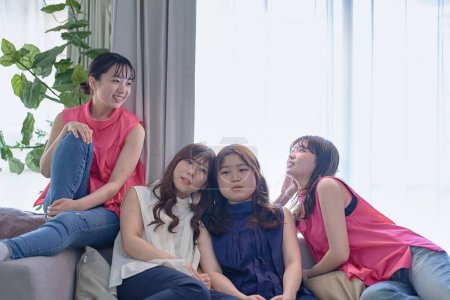 Téléchargez les photos : Quatre jeunes femmes se relaxant dans la chambre - en image libre de droit