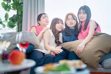 Photo for Four young women relaxing at a home party - Royalty Free Image