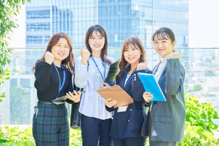Business women cheering outdoors with guts pose
