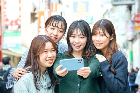 Foto de Cuatro mujeres felices tomando selfies en la ciudad - Imagen libre de derechos