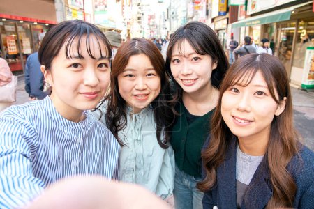 Téléchargez les photos : Quatre jeunes femmes prenant des selfies dans la ville - en image libre de droit