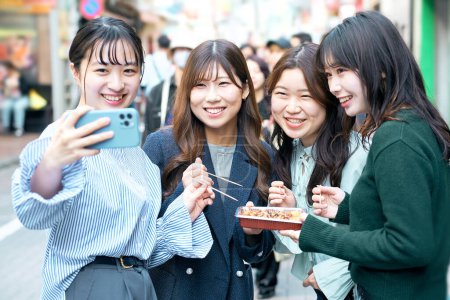 Photo for Four young women taking selfies in the city - Royalty Free Image