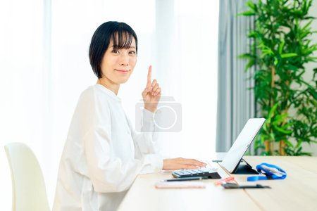 Téléchargez les photos : Asiatique femme à l'aide d'ordinateur portable dans la chambre - en image libre de droit