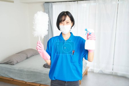 Téléchargez les photos : Une femme en vêtements de travail nettoie la pièce - en image libre de droit