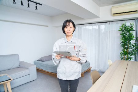Foto de Una mujer con ropa de trabajo revisando la habitación - Imagen libre de derechos