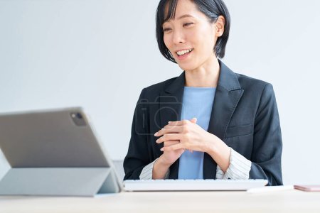 Téléchargez les photos : Femme d'affaires utilisant tablette pc pour la communication en ligne dans la chambre - en image libre de droit