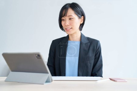 Téléchargez les photos : Femme d'affaires utilisant tablette pc pour la communication en ligne dans la chambre - en image libre de droit