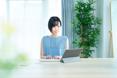 Téléchargez les photos : Asiatique femme à l'aide d'ordinateur portable dans la chambre - en image libre de droit