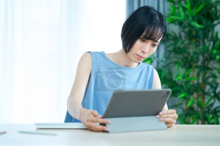 Téléchargez les photos : Une femme touchant un ordinateur avec une expression gênante dans la pièce - en image libre de droit