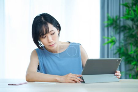 Téléchargez les photos : Une femme touchant un ordinateur avec une expression gênante dans la pièce - en image libre de droit
