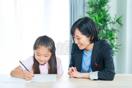 Photo for A girl studying and a woman in a suit to support in the room - Royalty Free Image