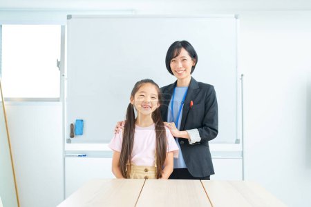 Photo for A girl and a woman in a suit standing in front of a whiteboard - Royalty Free Image