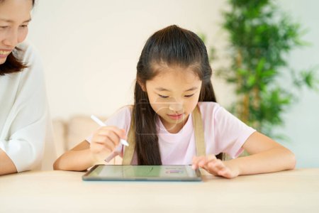 Téléchargez les photos : Parent et enfant jouent avec une tablette PC dans la chambre - en image libre de droit