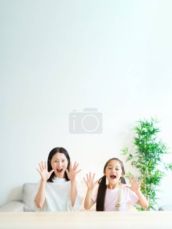 Téléchargez les photos : Parent et enfant faisant une pose surprise dans la chambre - en image libre de droit
