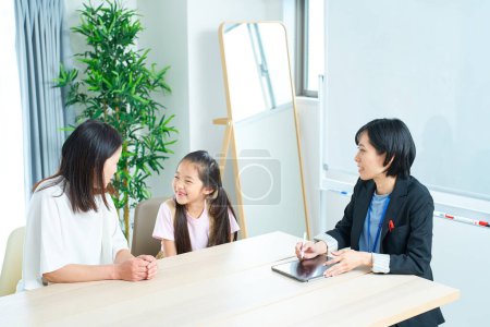Photo for Conversation scene of a woman in a suit with a parent and child in the room - Royalty Free Image