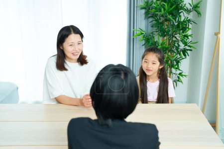 Téléchargez les photos : Scène de conversation d'une femme en costume avec un parent et un enfant dans la chambre - en image libre de droit
