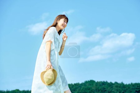 Téléchargez les photos : Une jeune femme montrant une expression détendue sous le ciel clair - en image libre de droit