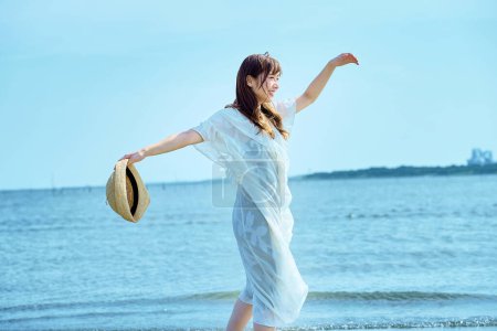 Téléchargez les photos : Femme marchant sur la plage le beau jour - en image libre de droit