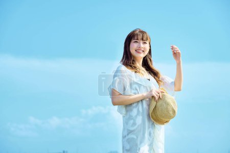 Photo for Woman walking on the beach on fine day - Royalty Free Image