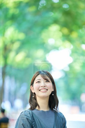Photo for Smiling woman portrait at greenful street on fine day - Royalty Free Image