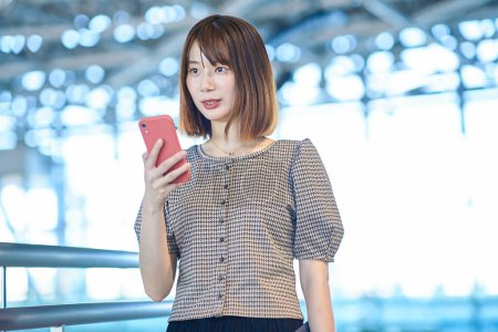 Photo for Asian young business woman operating a smartphone - Royalty Free Image