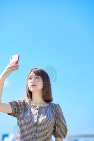 Foto de Asiática joven mujer de negocios operando un teléfono inteligente - Imagen libre de derechos