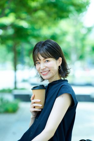 Foto de Mujer joven bebiendo café en la esquina de la calle - Imagen libre de derechos