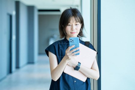 Photo for Asian young woman holding a smartphone - Royalty Free Image