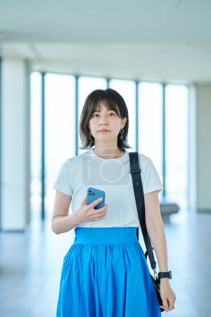 Téléchargez les photos : Asiatique jeune femme tenant un smartphone - en image libre de droit