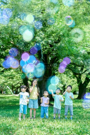 Kinder spielen im Park mit Seifenblasen