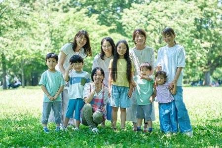 Gruppenbild von Kindern, Eltern und einer Lehrerin im Park