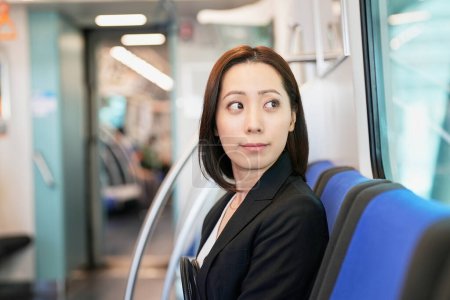 Téléchargez les photos : Femme d'affaires assise sur un siège de train - en image libre de droit