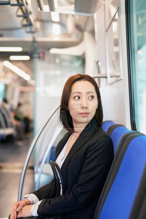 Photo for Business woman sitting on a train seat - Royalty Free Image
