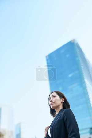 Foto de Mujer de negocios mirando al cielo en la ciudad - Imagen libre de derechos