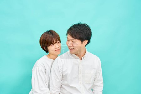 Photo for Man and woman in a friendly atmosphere in front of blue background - Royalty Free Image