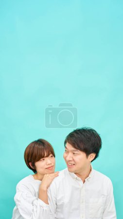 Téléchargez les photos : Homme et femme dans une ambiance conviviale devant fond bleu - en image libre de droit