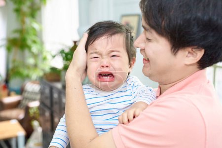 Photo for Crying baby and parents holding each other - Royalty Free Image