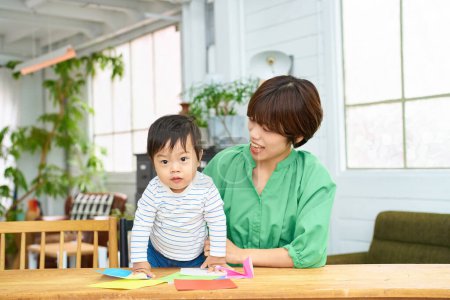 Photo for Parent and child playing origami indoors - Royalty Free Image