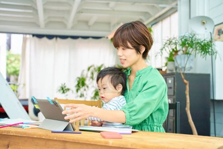 Foto de Una mujer que trabaja desde casa con un bebé - Imagen libre de derechos