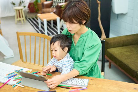 Téléchargez les photos : Une femme qui travaille à la maison avec un bébé - en image libre de droit