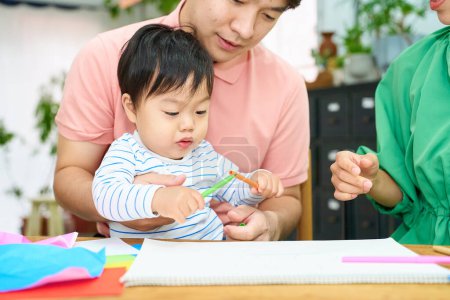 Photo for Parent and child drawing and playing indoors - Royalty Free Image