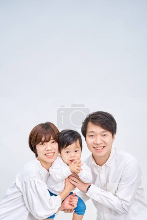 Téléchargez les photos : Famille souriant et aligné devant fond blanc - en image libre de droit