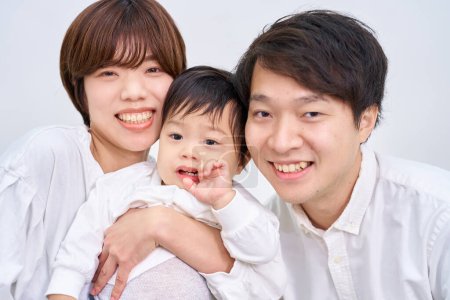 Téléchargez les photos : Famille souriant et aligné devant fond blanc - en image libre de droit
