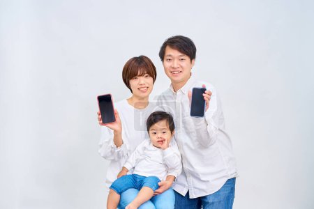 Foto de Familia feliz mostrando la pantalla del teléfono inteligente frente al fondo blanco - Imagen libre de derechos