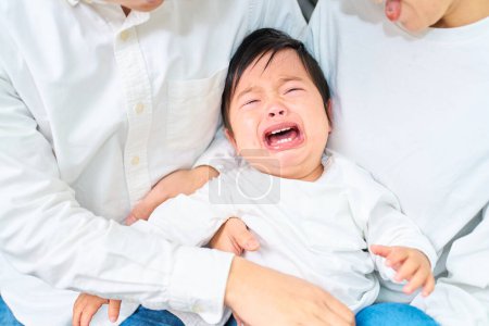 Téléchargez les photos : Pleurer bébé et parents se tenant l'un l'autre - en image libre de droit