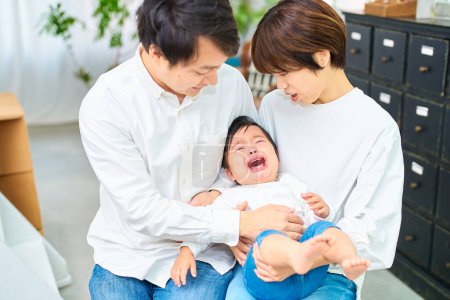 Téléchargez les photos : Pleurer bébé et parents se tenant l'un l'autre - en image libre de droit