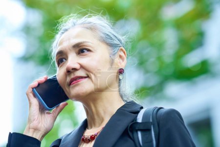 Foto de Mujer mayor hablando en el teléfono inteligente al aire libre - Imagen libre de derechos