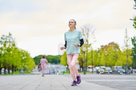 Photo for Energetic senior woman running in the city - Royalty Free Image