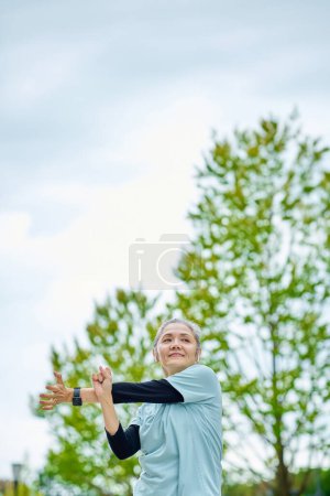 Téléchargez les photos : Femme âgée souriante faisant de l'exercice à l'extérieur - en image libre de droit